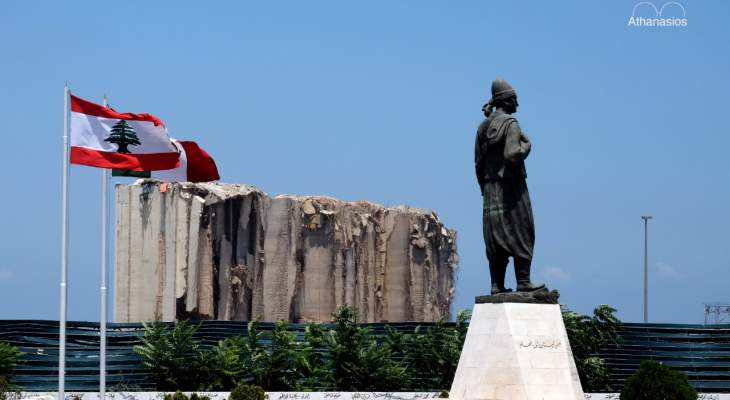 صورة للأب أثناسيوس شهوان تجمع انفجار المرفأ وتمثال المهاجر اللبناني