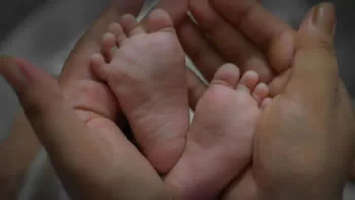 رضيع عارٍ مرمية في قطعة أرض